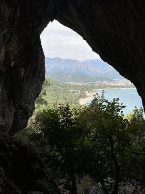 Dağlardaki kaya yarığında küçük bir mağara. Dikitleri ve sarkıtları olan turistik bir mağara. Yazın ormandaki kaya mağarası