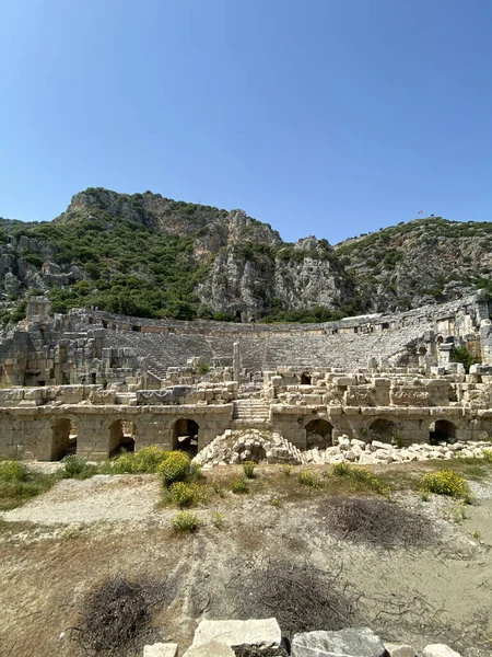 Historical Stone faces bas relief and ancient theater at Myra ancient city. Rock-cut tombs Ruins in Lycia region, Demre, Antalya, Turkey. Archeological remains of the Lycian rock cut tombs
