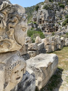 Tarihi Taş, Myra antik şehrinde bas rahatlama ve antik tiyatro ile karşı karşıya. Lycia, Demre, Antalya, Türkiye 'de taş kesimi mezarlar harabe. Lycia kaya kesiminin mezarlarının arkeolojik kalıntıları