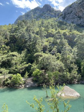 Yazın güneşli bir günde dağların arka planında sakin su bulunan zümrüt göl, Kemer, Lycia, Türkiye yakınlarındaki Goynuk kanyonu. Doğa konseptinin güzelliği.