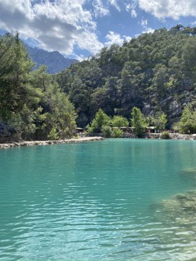 Yazın güneşli bir günde dağların arka planında sakin su bulunan zümrüt göl, Kemer, Lycia, Türkiye yakınlarındaki Goynuk kanyonu. Doğa konseptinin güzelliği.