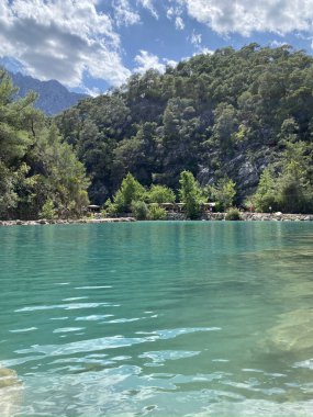 Yazın güneşli bir günde dağların arka planında sakin su bulunan zümrüt göl, Kemer, Lycia, Türkiye yakınlarındaki Goynuk kanyonu. Doğa konseptinin güzelliği.