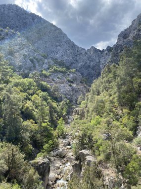 Yazın güneşli bir günde dağların arka planında sakin su bulunan zümrüt göl, Kemer, Lycia, Türkiye yakınlarındaki Goynuk kanyonu. Doğa konseptinin güzelliği.