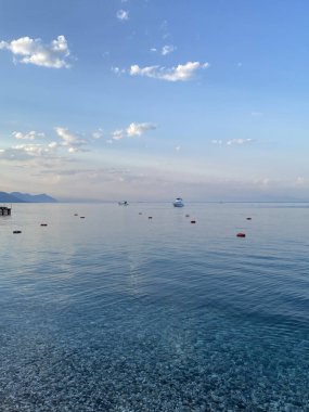 Deniz kıyısında çakıl taşları, deniz arka planı. Bir deniz dalgası bir çakıl taşı plajını yıkar. Antalya ilinin Kemer ilçesine bağlı Akdeniz kıyısındaki sahil manzarası