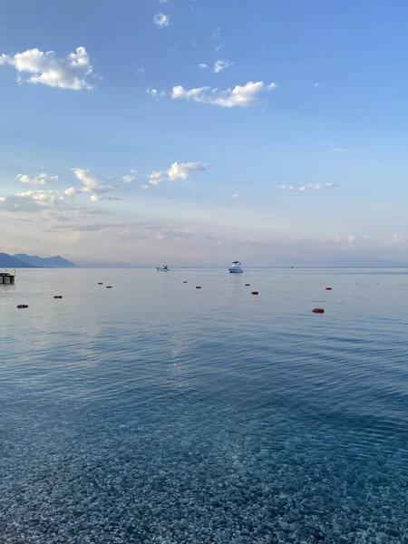Deniz kıyısında çakıl taşları, deniz arka planı. Bir deniz dalgası bir çakıl taşı plajını yıkar. Antalya ilinin Kemer ilçesine bağlı Akdeniz kıyısındaki sahil manzarası