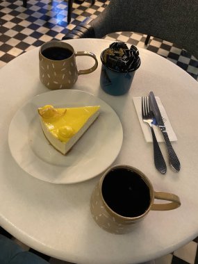 Cheesecake ve kahve masada, lezzetli limonlu pasta.