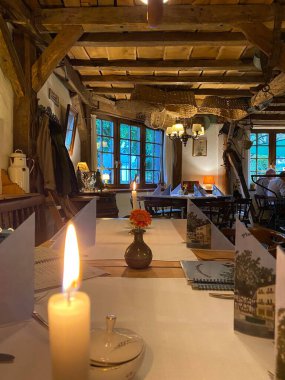 Bir kafe 'nin içi. Şehir merkezinde masa ve sandalyeleri, kolye aydınlatması ve şehir manzaralı pencereleri olan bir binanın iç tasarım fotoğrafları.