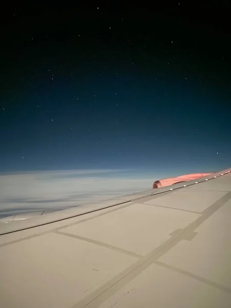 Travelling by air plane, looking through plane window enjoying beautiful night sky full of stars and milky way