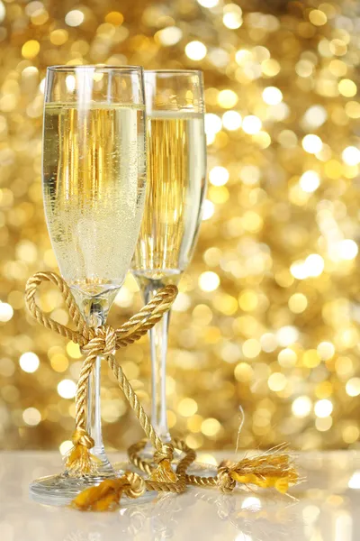 Champagne flutes with golden background — Stock Photo, Image