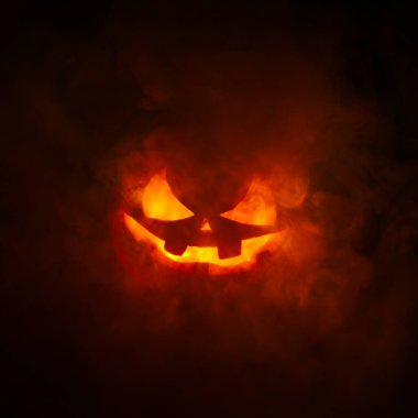 Ürkütücü oyma Jack o Fener kızgın kırmızı bir duman içinde yüzünde korkunç bir sırıtışla dışarı süzülüyordu..