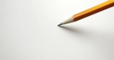 Sarı kalemle kağıt üzerinde dalgalı bir çizgi çiziyor..