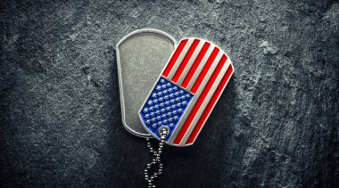 Amerikan askerinin künyesi, sert ve üzerinde yazı için boşluk olan, Amerikan bayrağı şeklinde. Gaziler Günü konsepti için anma günü.