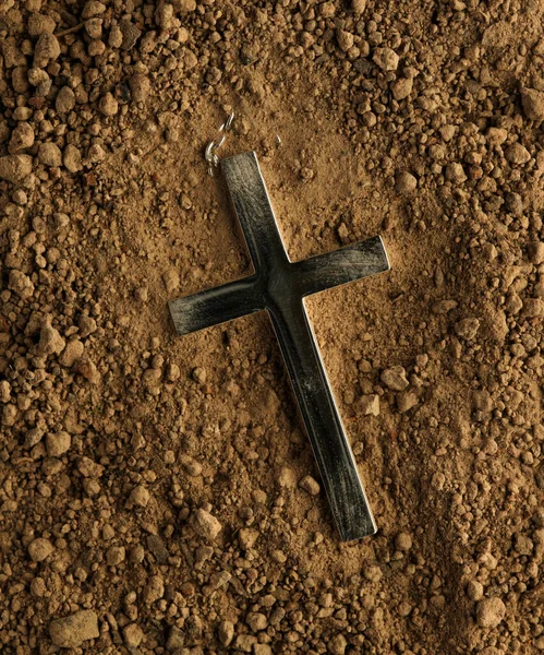 基督教十字项链埋在地下 泥土从十字架上擦去 — 图库照片