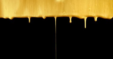 Vivid metallic gold paint flowing and dripping.