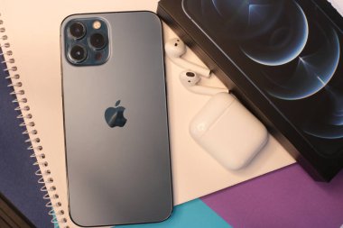Nizhny Novgorod, Rusya - 13 Ekim 2021: Yeni iPhone 12 Pro Max Smartphone Pacific Blue ve Earpod