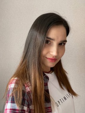 Beyaz tişörtlü güzel bir kızın özçekim fotoğrafı. Üzerinde yazıt iyimserliği var.