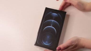 Moskova, Rusya - 2 Şubat 2022: Yeni iPhone 12 Pasifik mavi üç kameranın boksunu açmak