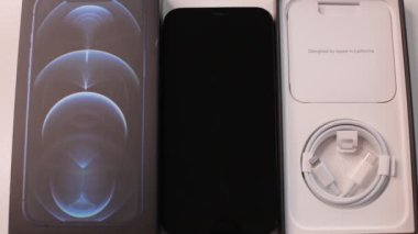 Moskova, Rusya - 2 Şubat 2022: Yeni iPhone 12 Pasifik mavi üç kameranın boksunu açmak