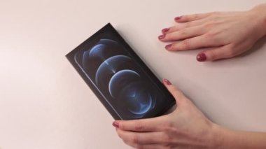 Moskova, Rusya - 2 Şubat 2022: Yeni iPhone 12 Pasifik mavi üç kameranın boksunu açmak