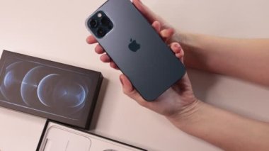 Moskova, Rusya - 2 Şubat 2022: Yeni iPhone 12 Pasifik mavi üç kameranın boksunu açmak