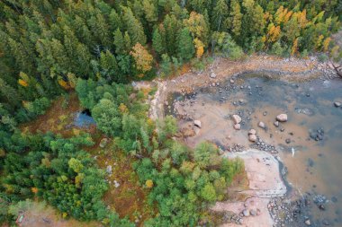 Kuzey gölünün kayalık kıyısındaki küçük göl ve orman, tepeden aşağıya insansız hava aracı