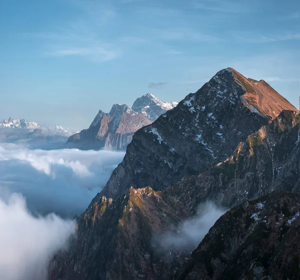 Montaña Picos Nevados Sobre Densas Nubes Contra Cielo Azul — Foto de Stock