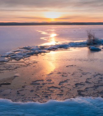  Kıyıda taze kar, kışın gün batımında buz ve karla kaplı göl, Vuoksa, Leningrad bölgesi.