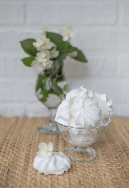 Meringue cake with a jasmine flowers on background