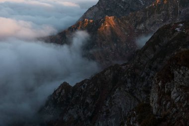 Fantastic dreamy sunrise on top of rocky mountain .Mountain view.Foggy Sunrise clouds. .Misty peaks.Foggy landscape background.