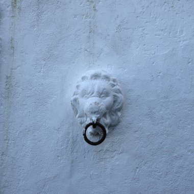 Aslan başlı ve yüzüklü eski bir kapı kolu.