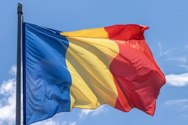Mavi gökyüzü arka planında dalgalanan Romanya ulusal bayrağı. Romanya, RO