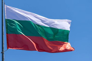 Mavi gökyüzü arka planında Bulgar ulusal bayrağı dalgalanıyor. Bulgaristan Cumhuriyeti, BG