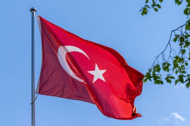 Mavi arka planda dalgalanan Türk ulusal bayrağı. Türkiye Cumhuriyeti, TR