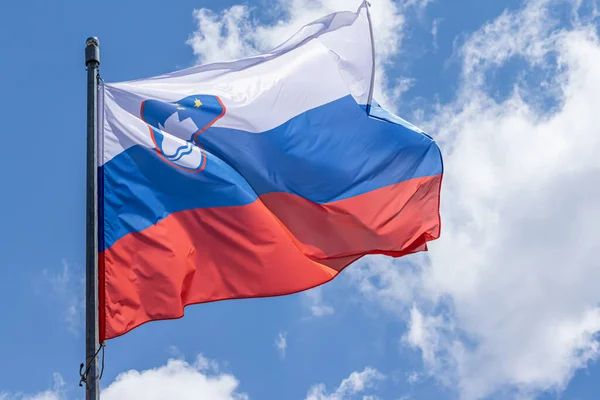 Mavi gökyüzü arka planında sallanan Sloven ulusal bayrağı. Slovenya Cumhuriyeti, SL