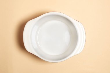 Bej arka planda izole edilmiş boş seramik çorba kasesinin üst görüntüsü. Boş seramik tava. Yemek pişirmek için düz tabaka