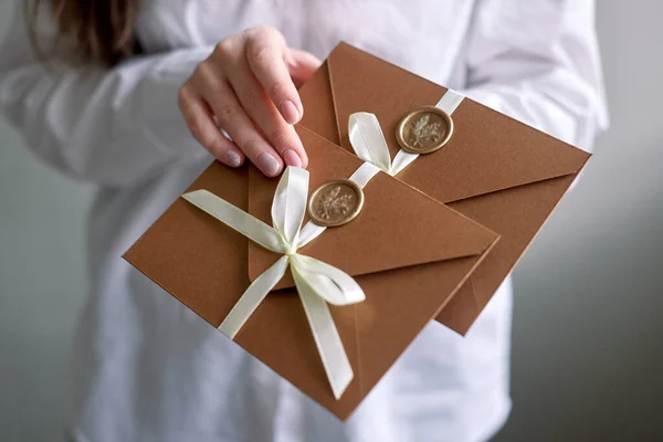 woman hold sealed envelopes. invitation envelope with ribbon and wax seal, gift certificate, wedding invitation card