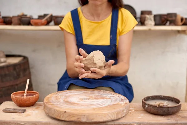 Potter with wet clay pot in hands. pottery hobby woman hands sculpt in clay