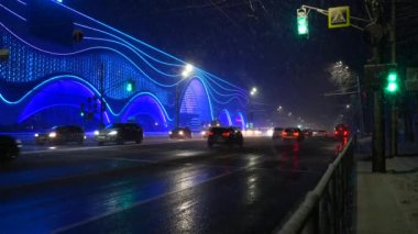 Sokak. Kışın, kar yağarken, kar fırtınası varken arabalar yollara düşer.