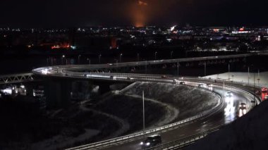 Şehrin arka planında otoban var. Kış mevsiminde kar yağdıktan sonra arabalar yollara düşer.