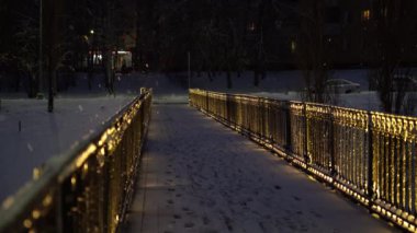 Bir kış akşamı kar fırtınasında fenerli yaya köprüsü, kar fırtınası. Yoldan bir araba geliyor.