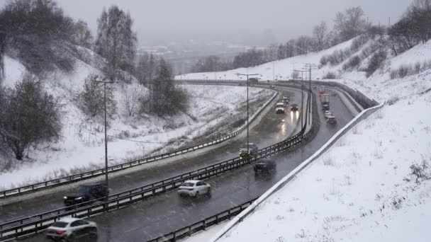 Śnieżyca. Samochody jadące po śnieżnej autostradzie w zimie, ruch na drodze w śniegu — Wideo stockowe