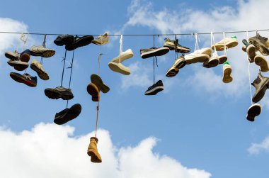 Flensburg, Almanya - 04 Eylül 2021: Flensburg 'da sokak sanatı için tele asılan ayakkabılar