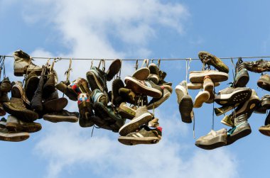 Flensburg, Almanya - 04 Eylül 2021: Flensburg 'da sokak sanatı için tele asılan ayakkabılar