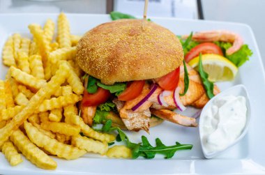 Izgara somonlu sandviç ve patates kızartması.