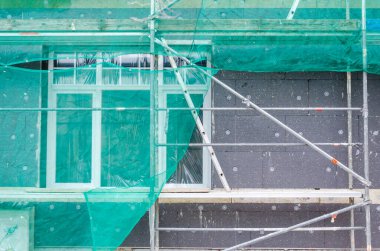 İskeleli duvar inşaatının modern düzeni. Dış duvar yalıtım sistemleri.