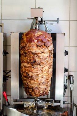 Doner kebab meat on a rotating vertical spit.