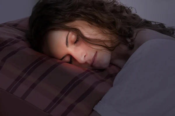 Mujer durmiendo en una almohada roja — Foto de Stock