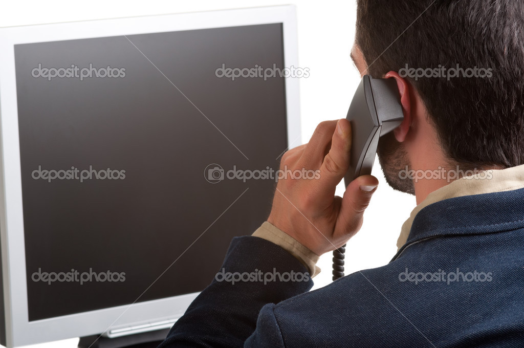 Casual Businessman Talking over the Phone and Looking at a Compu