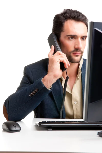 Mann schaut auf Computermonitor, am Telefon — Stockfoto