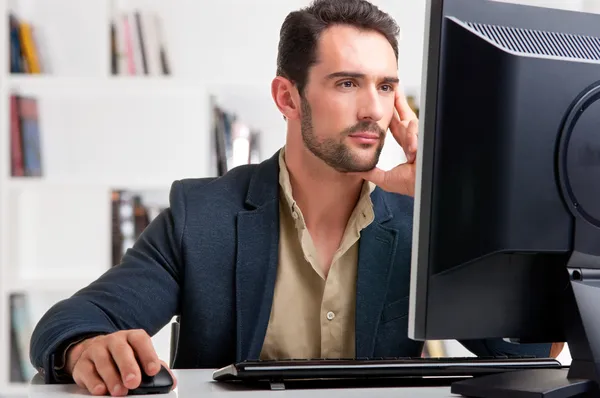 Hombre mirando un monitor de computadora Imágenes de stock libres de derechos
